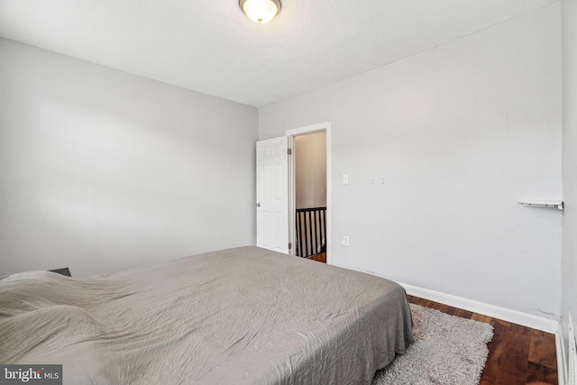 bedroom with baseboards and wood finished floors