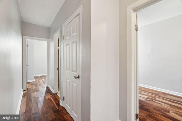 corridor with wood finished floors and baseboards