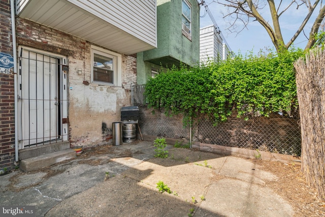 doorway to property featuring stucco siding and fence