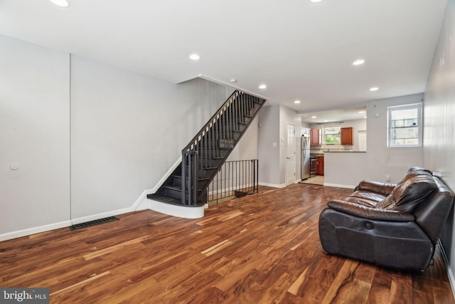 living room with wood finished floors, recessed lighting, and stairs