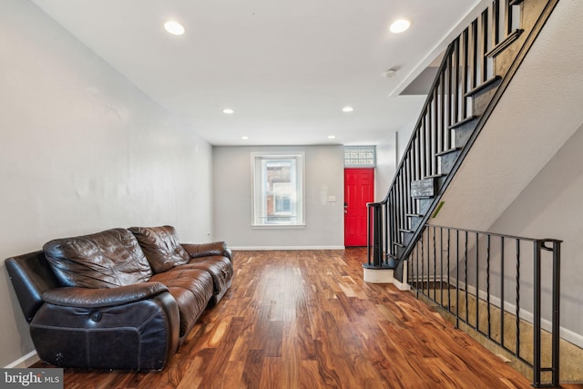living area with recessed lighting, stairs, wood finished floors, and baseboards