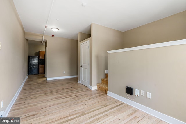 empty room with light wood-style floors and baseboards