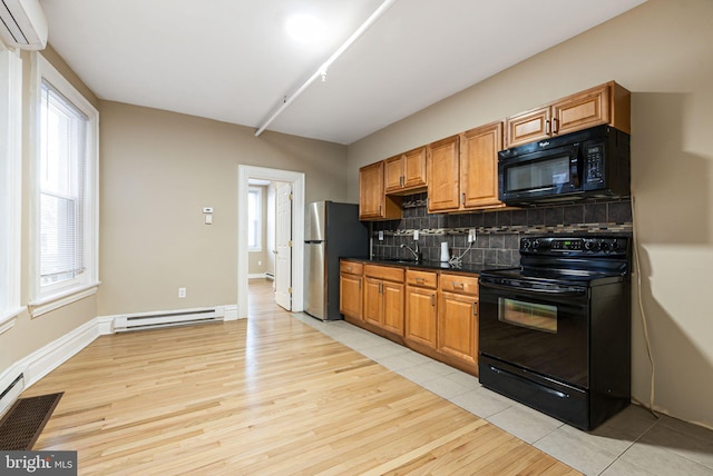 kitchen featuring backsplash, dark countertops, a wall mounted AC, black appliances, and a baseboard heating unit