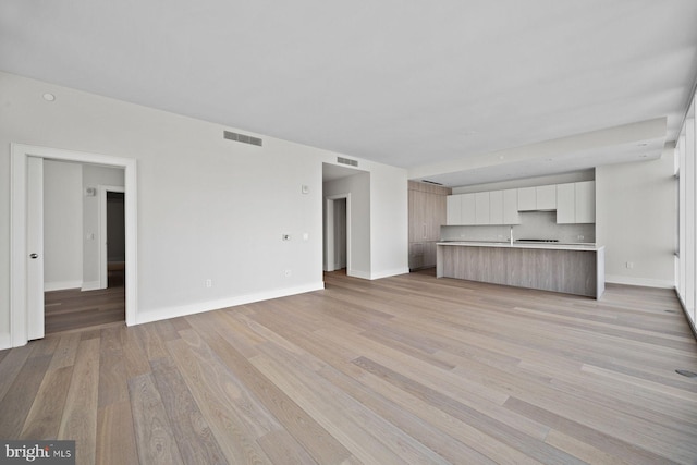 301 S Broad St Unit 1901-2, Philadelphia, PA 19107 - unfurnished living room featuring light wood-style floors, visible vents, and baseboards