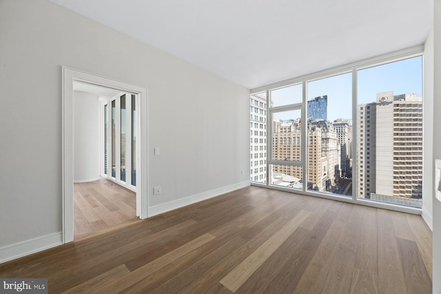 301 S Broad St Unit 1901-2, Philadelphia, PA 19107 - spare room with a wall of windows, wood finished floors, baseboards, and a view of city