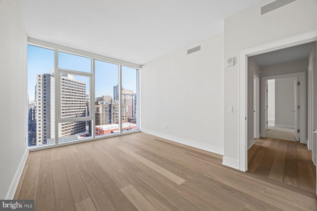 301 S Broad St Unit 1901-2, Philadelphia, PA 19107 - spare room featuring baseboards, wood finished floors, and visible vents