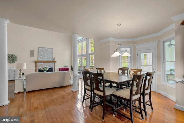 dining space with baseboards, light wood-type flooring, visible vents, and ornate columns