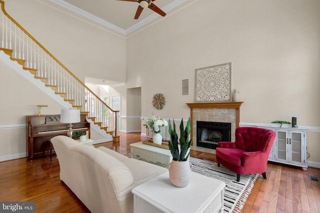 living room with ceiling fan, stairway, hardwood / wood-style floors, and baseboards
