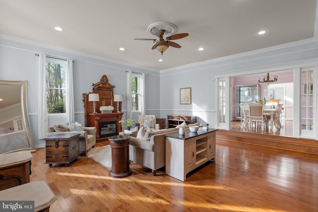 living area featuring crown molding, a healthy amount of sunlight, and light wood-type flooring