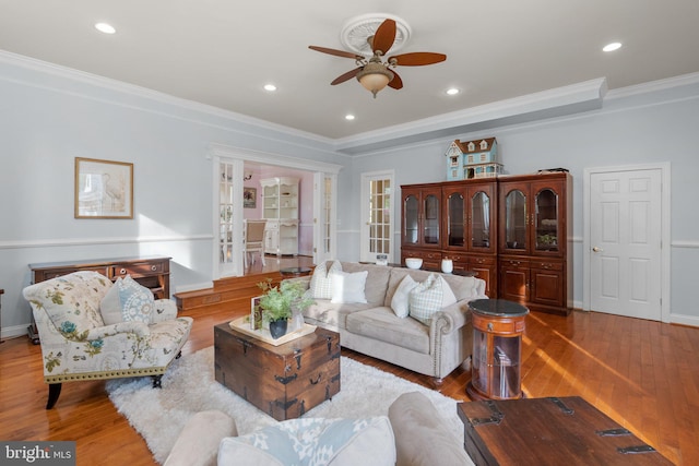 living area featuring crown molding, ceiling fan, baseboards, recessed lighting, and wood finished floors