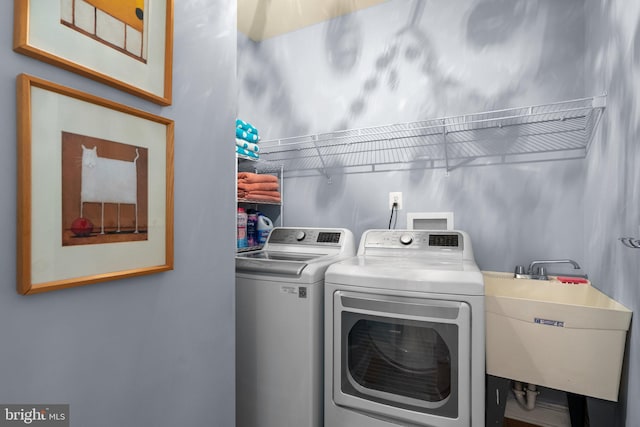 laundry area with a sink, laundry area, and washing machine and dryer