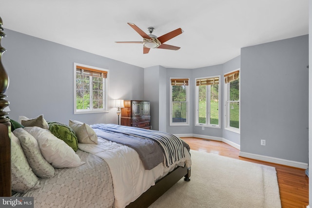 bedroom featuring baseboards, wood finished floors, and ceiling fan