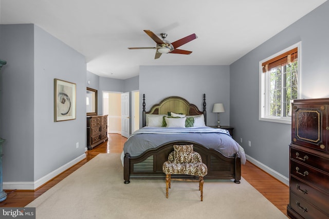 bedroom with wood finished floors, ceiling fan, and baseboards