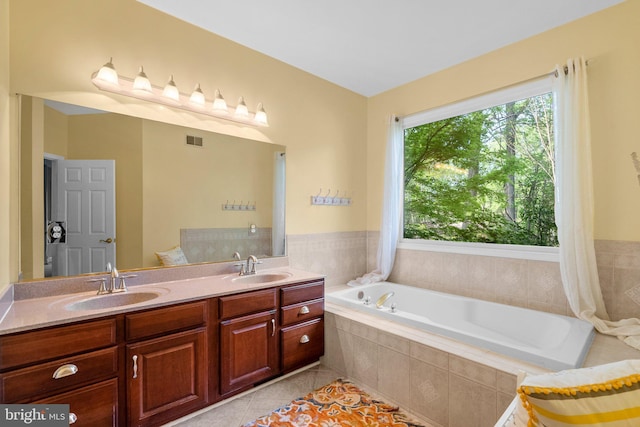 full bathroom with tile patterned floors, visible vents, a garden tub, and a sink