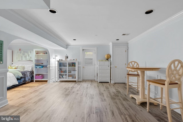 sitting room featuring crown molding, arched walkways, visible vents, and wood finished floors