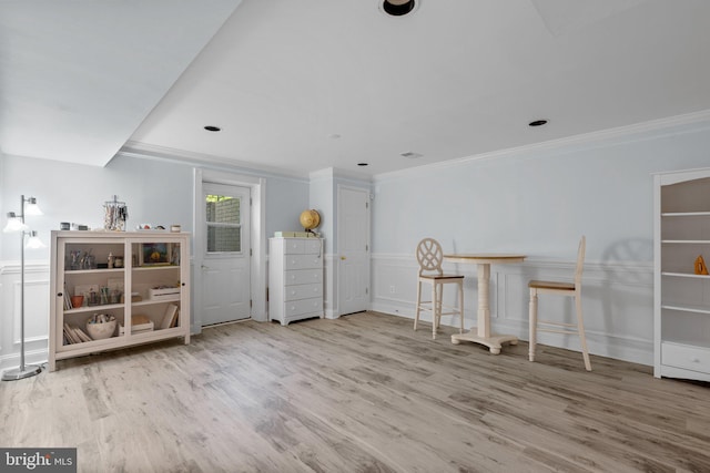 interior space featuring wainscoting, wood finished floors, and crown molding