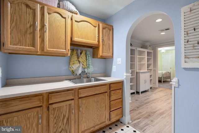 kitchen with recessed lighting, a sink, visible vents, light countertops, and arched walkways