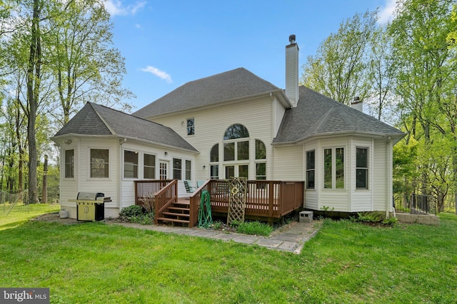 back of house featuring a chimney, a yard, and a wooden deck