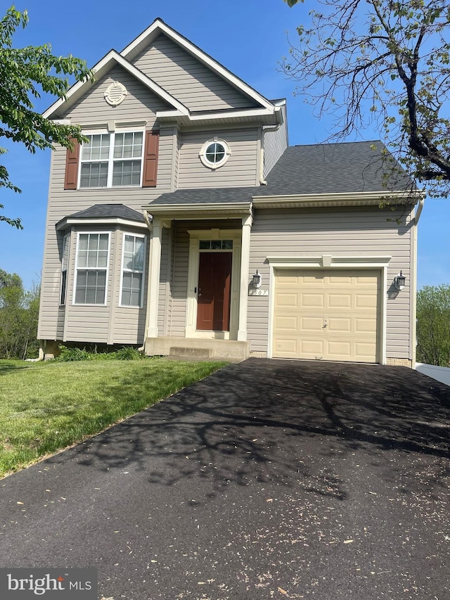 view of front of house with a garage, driveway, and a front lawn