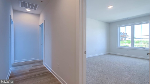 hall featuring recessed lighting, baseboards, visible vents, and wood finished floors