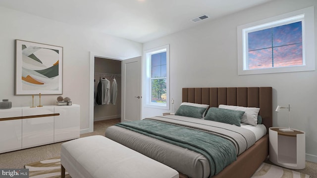 bedroom with a walk in closet, visible vents, baseboards, a closet, and light carpet