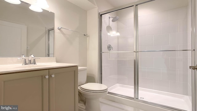 bathroom featuring vanity, toilet, and a stall shower