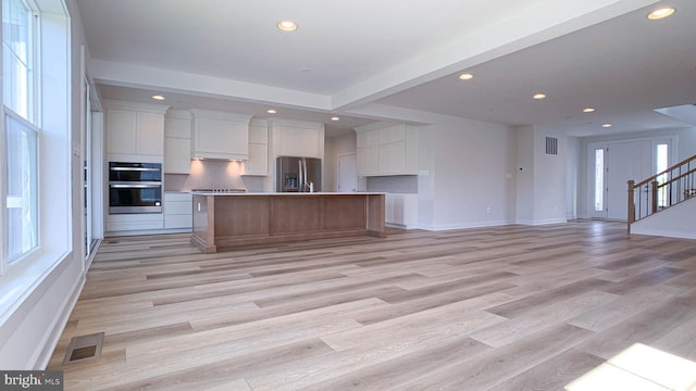 kitchen featuring white cabinets, appliances with stainless steel finishes, recessed lighting, open floor plan, and visible vents