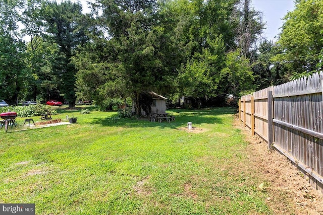 view of yard featuring an outbuilding, a shed, and fence