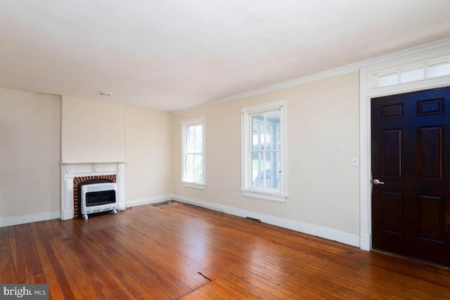 unfurnished living room with hardwood / wood-style floors, baseboards, a fireplace, and crown molding