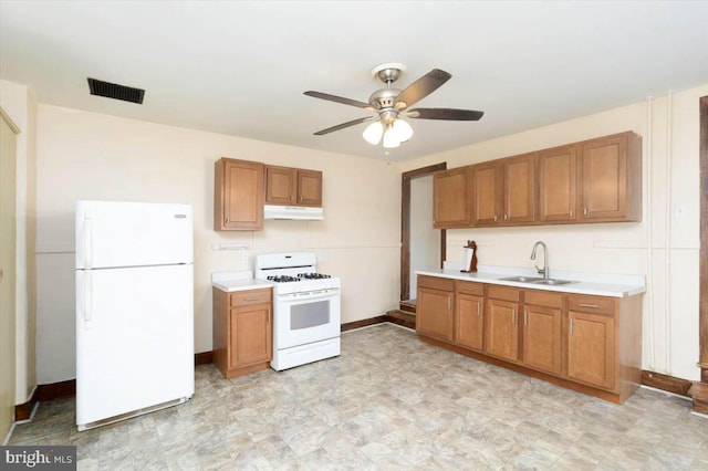 kitchen with under cabinet range hood, light countertops, visible vents, a sink, and white appliances