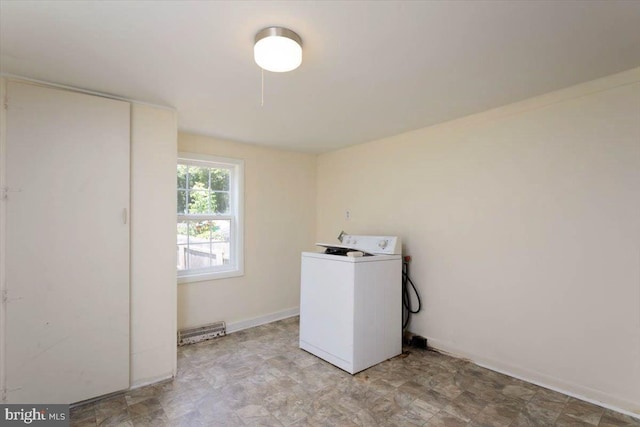 clothes washing area with washer / dryer, baseboards, and laundry area