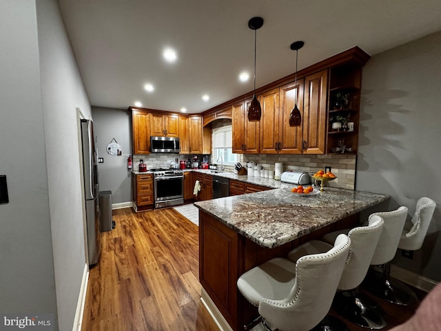 766 President, Lawrenceville, NJ 08648 - kitchen with a peninsula, backsplash, stone countertops, brown cabinetry, and appliances with stainless steel finishes