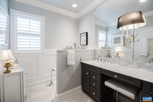 bathroom with a decorative wall, wainscoting, vanity, ornamental molding, and recessed lighting