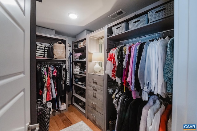 walk in closet with wood finished floors and visible vents