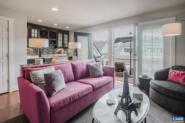 living room featuring wood finished floors, indoor bar, and recessed lighting