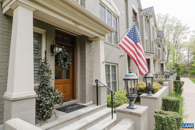 view of exterior entry featuring brick siding