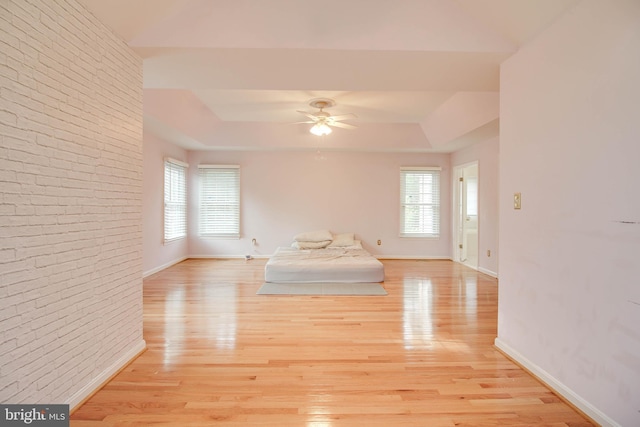 interior space with baseboards, ceiling fan, light wood finished floors, and a wealth of natural light