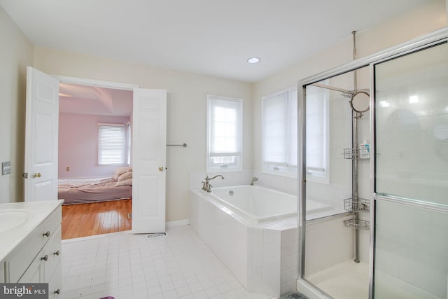 bathroom featuring tile patterned flooring, vanity, a shower stall, ensuite bathroom, and a garden tub