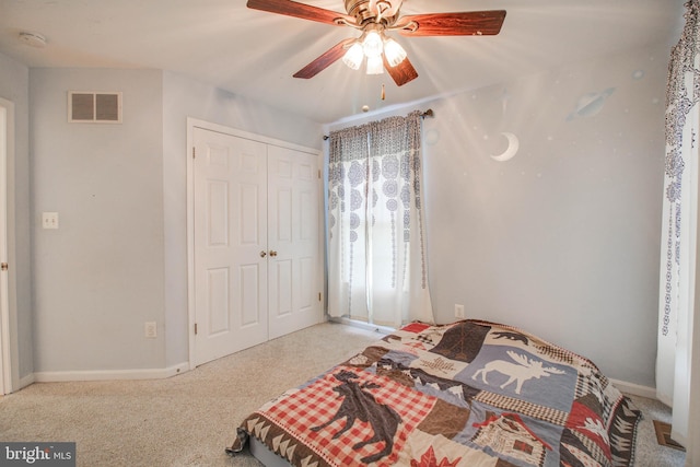 bedroom featuring baseboards, visible vents, light carpet, and a closet