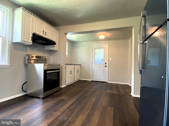 kitchen with under cabinet range hood, freestanding refrigerator, baseboards, range, and dark wood-style flooring