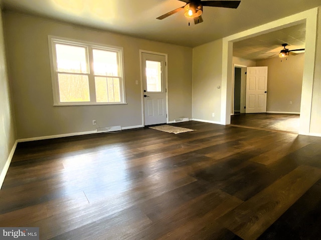 interior space with baseboards, a ceiling fan, and wood finished floors