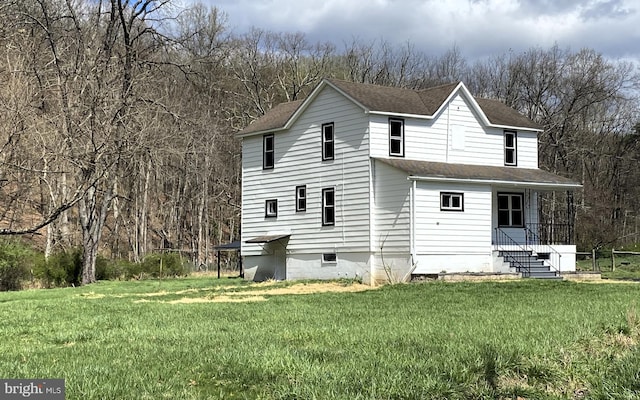 back of house featuring a lawn, roof with shingles, and crawl space