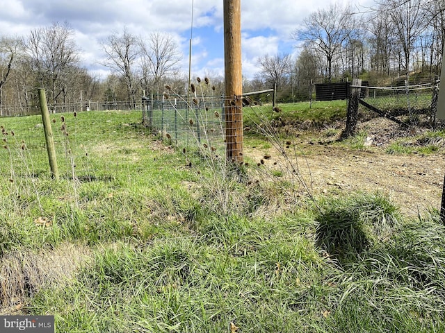 view of yard with a rural view and fence