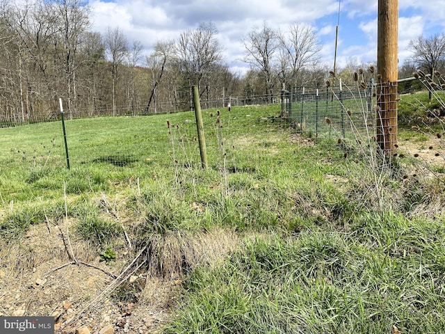 view of yard with fence and a rural view