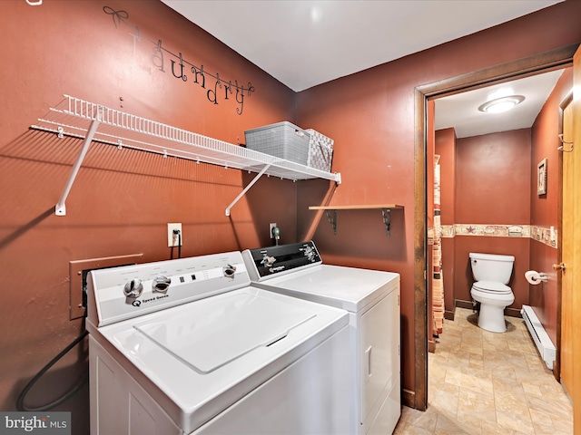 washroom with a baseboard heating unit, washing machine and dryer, and laundry area