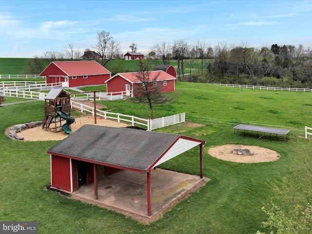 view of home's community featuring fence, a yard, a rural view, and a playground