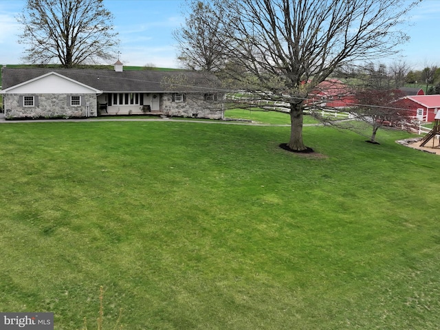 view of front facade featuring stone siding and a front yard