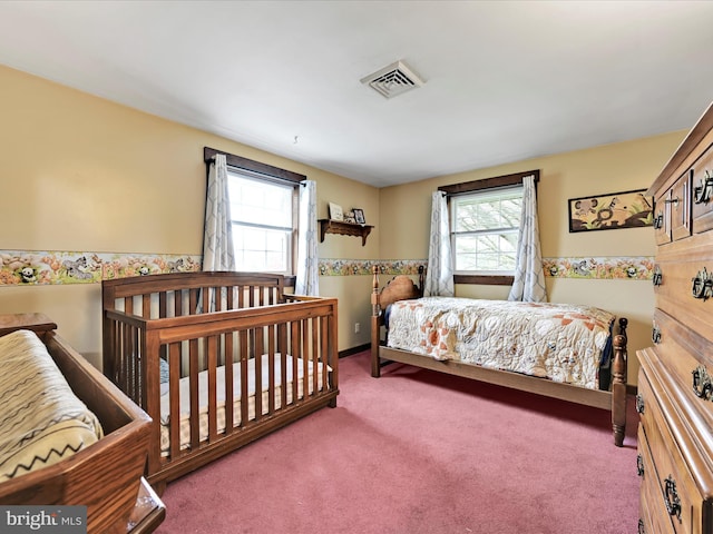 carpeted bedroom with visible vents and multiple windows