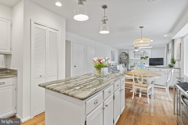 kitchen with a center island, white cabinets, and light wood finished floors