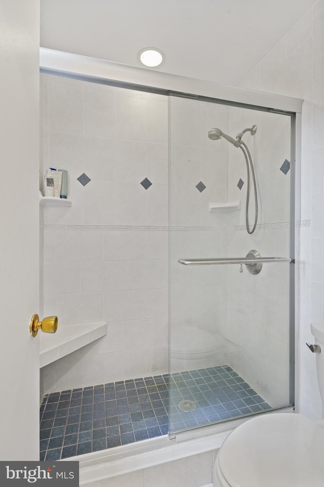 full bath with toilet and a stall shower